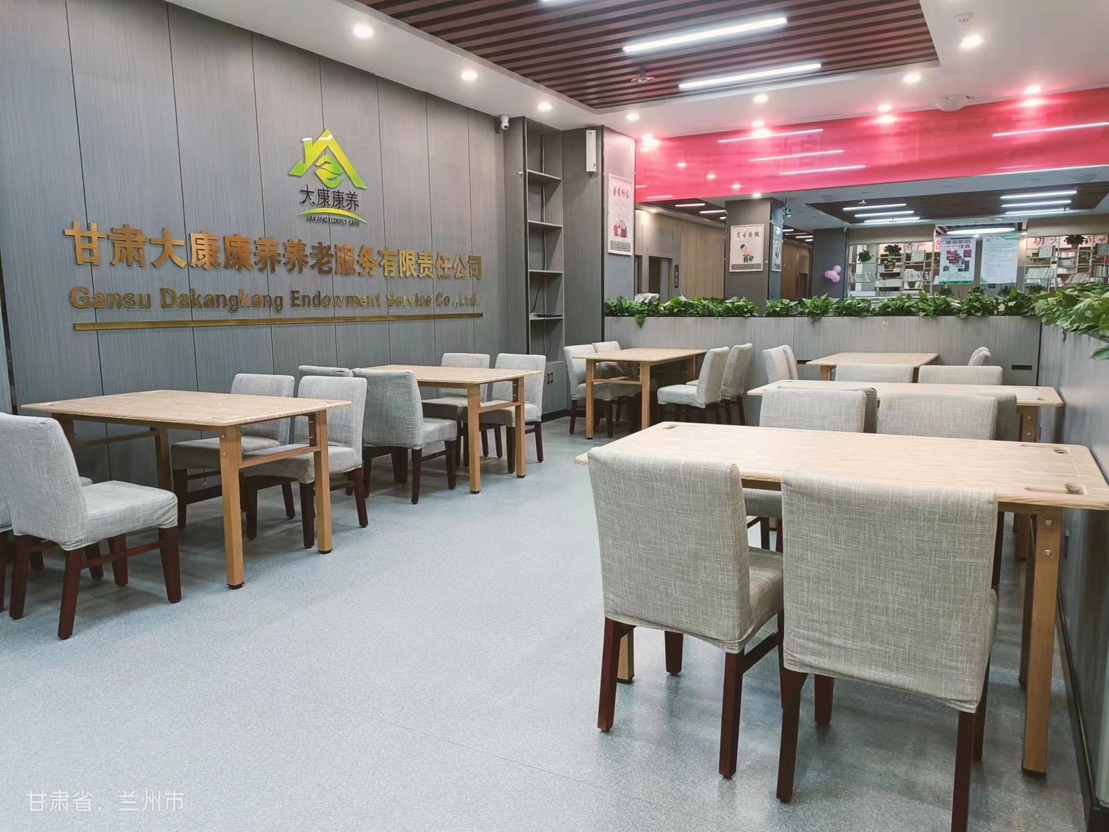 养老中心整洁明亮的餐厅，摆放木质餐桌和软包餐椅